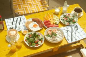 a table with plates of breakfast food on it at The Beach Road cabin kohlarn in Ko Larn
