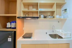 una cocina con fregadero y encimera en Nice and Compact Studio at Tokyo Riverside PIK 2 Apartment By Travelio, en Rawalembang 8 fotos más