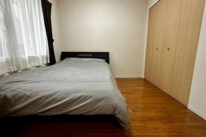 a bedroom with a bed and a large window at 302便利な立地札幌駅が徒歩7分の超人気で美室女性に人気 in Kita-rokujō