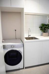 una cocina con lavadora y fregadero en Moonee Valley Terrace, en Melbourne 29 fotos más