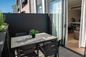 una mesa con una maceta en el balcón en Moonee Valley Terrace, en Melbourne