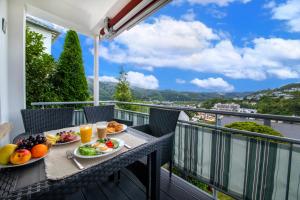 巴特埃姆斯PMC Ferienhaus Traumblick的阳台上摆放着水果和果汁的桌子