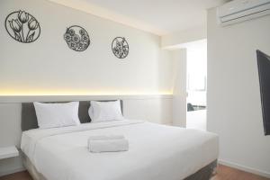 Un pat sau paturi într-o cameră la New and Minimalist Stay 2BR at Daan Mogot City Apartment By Travelio +17 fotografii