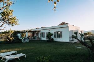 a white house with a bench in the yard at Kepos room in Tortolì