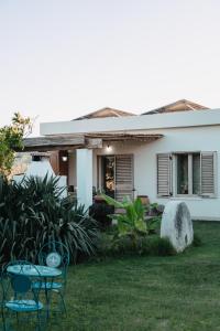 a house with two chairs and a table in the yard at Kepos room in Tortolì