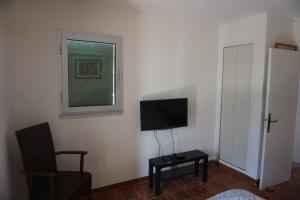 a room with a tv and a chair and a window at Presqu`ile de Giens in Hyères