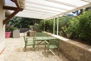 a patio with a table and chairs under a pergola at Presqu`ile de Giens in Hyères