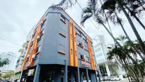 a building with orange doors and palm trees on a street at Hi-Inn in Miri