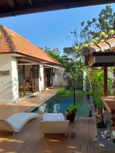 a house with a swimming pool and a wooden deck at The Seaglass Villas Bingin in Uluwatu