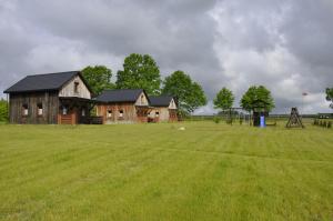 a large field with a house and a playground at Derkacz in Wołogoszcz