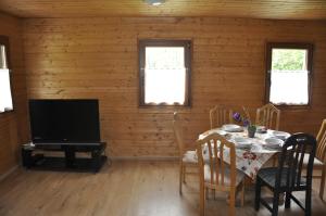a dining room with a table and a television at Derkacz in Wołogoszcz
