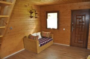 a room with a couch in a log cabin at Derkacz in Wołogoszcz