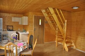 a wooden room with a table and a ladder in it at Derkacz in Wołogoszcz +5 photos