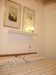 コネリアーノにあるCasa delle Bruscoleのベッドルーム1室(ベッド1台付)が備わります。壁に2枚の写真が飾られています。