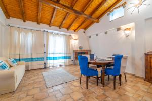 a living room with a table and blue chairs at PV9 by DomusAway in Olbia