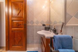 a bathroom with a sink and a wooden door at PV9 by DomusAway in Olbia