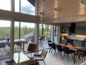 a dining room with tables and chairs in a room with windows at Villa Jämsä in Säyrylä