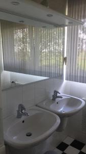 a bathroom with two sinks and a mirror at Wide ie Grou in Nes
