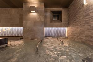 a pool of water in a room with a stone wall at Hotel Vista Kanazawa in Kanazawa