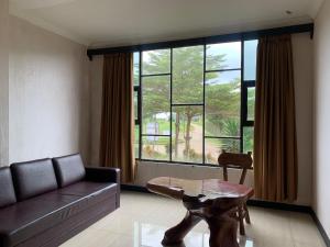 - un salon avec un canapé et une table en face d'une fenêtre dans l'établissement Cikidang Resort, à Sukabumi