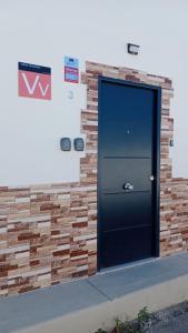 a black door on the side of a brick wall at New modern apartment, Scandinavian style, ocean view, huge terrace in Icod de los Vinos