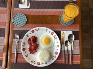 a plate of food with an egg and rice on a table at 1775 Adriatico Suites in Manila
