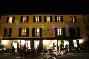 een gebouw met mensen die 's nachts buiten zitten bij Le Fin Chapon in Excideuil