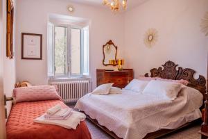 sypialnia z dwoma łóżkami i lustrem w obiekcie Casa Sole di Toscana con grande terrazza panoramica, giardino e vasca relax idromassaggio w mieście Monterotondo