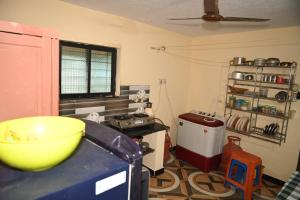 a kitchen with a large yellow bowl on a counter at Gennys Farm House in Sawantwadi +6 photos
