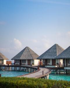 a row of overwater bungalows on the water at Adaaran Prestige Water Villas - with Dine around Premium All inclusive - 24 hours in Raa Atoll