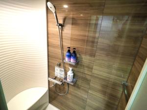 a bathroom with a shower with two bottles on shelves at Retreat Furano A in Furano +11 photos