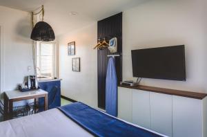 Habitación con cama y TV en la pared. en Mylo Hotel, en Daly City