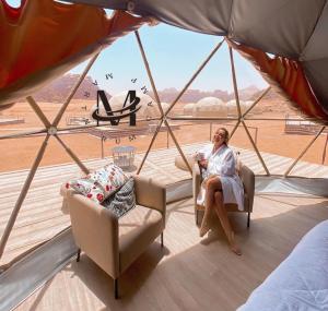 a woman sitting in a chair in a tent at RUM MARTiN BUBBLES lUXURY CAMP in Wadi Rum