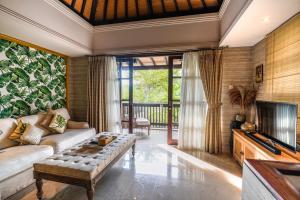 ein Wohnzimmer mit Couch und Fernseher in der Unterkunft The Springs Villas Jimbaran in Jimbaran