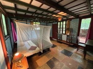 a room with a bed with a mosquito net at Khaama Kethna Eco Sustainable Village in Agonda