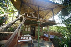 a small house with a balcony and a staircase at Khaama Kethna Eco Sustainable Village in Agonda