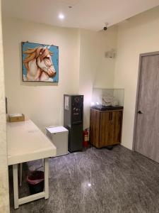 a room with a refrigerator and a painting of a horse on the wall at 好客來-正市區電梯別墅步行東大夜市3分鐘公正包子1分鐘 in Hualien City