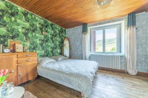 una camera da letto con un letto e una finestra di La Maison de Freda - Maison avec vue montagne a Beauregard