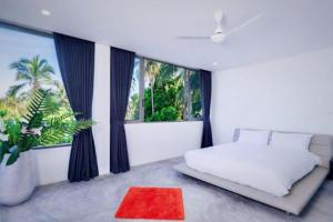 チャウエンノイビーチにある6-Bedrooms villa in Chaweng Noiのベッドルーム1室(白いベッド1台、赤いラグ付) +20枚の写真