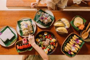 a wooden table with plates of food on it at Eco Eyes Village in Nakhon Nayok
