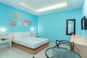 a room with a bed and a chair in it at โรงแรมนั่งเล่น in Chon Buri