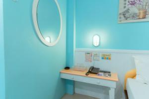 a blue room with a desk and a mirror at โรงแรมนั่งเล่น in Chon Buri