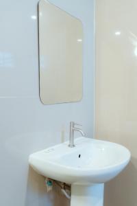 a white sink in a bathroom with a mirror at โรงแรมนั่งเล่น in Chon Buri