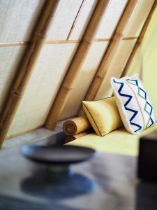 a room with two pillows sitting on a couch at Bamboo Living Siargao in Libertad +18 photos