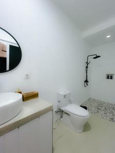 a bathroom with a toilet and a sink and a mirror at Volcano Garden in Kubupenlokan