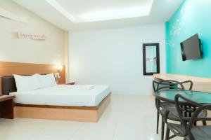 a hotel room with a bed and a table at โรงแรมนั่งเล่น in Chon Buri +16 photos