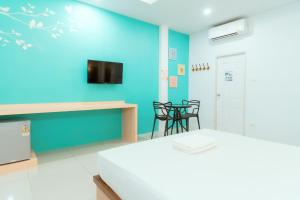 a room with a blue wall and a table and chairs at โรงแรมนั่งเล่น in Chon Buri