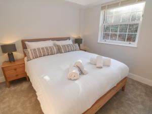 a bedroom with a large white bed with towels on it at Rock Mill Apartment in Eyam