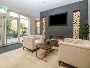 a living room with two chairs and a fireplace at Rock Mill Apartment in Eyam