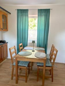 a dining room table with four chairs and a window at Tokaj Lamour in Tokaj